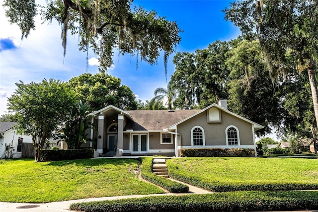 681 Greywood Dr, Altamonte Springs, FL 32701 - view of front facade with stucco siding, french doors, a front yard, and a chimney