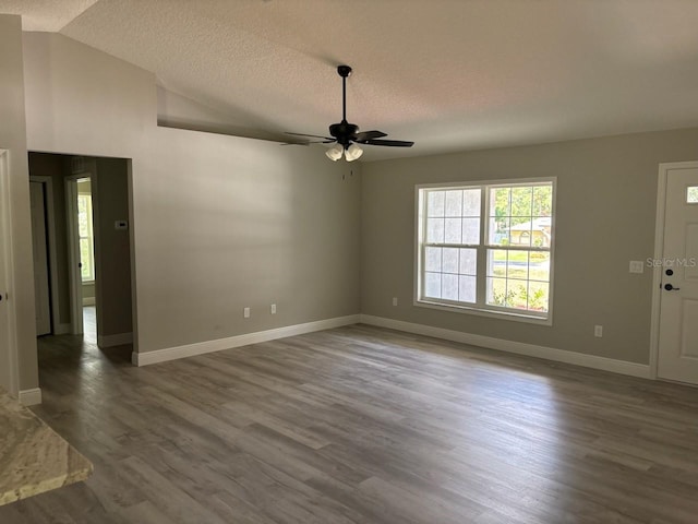 1176 W Bridge Dr, Citrus Springs, FL 34434 - empty room featuring a textured ceiling, ceiling fan, wood finished floors, and vaulted ceiling