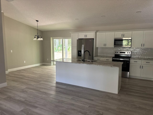 1176 W Bridge Dr, Citrus Springs, FL 34434 - kitchen with stainless steel appliances, a textured ceiling, decorative backsplash, white cabinets, and light stone countertops