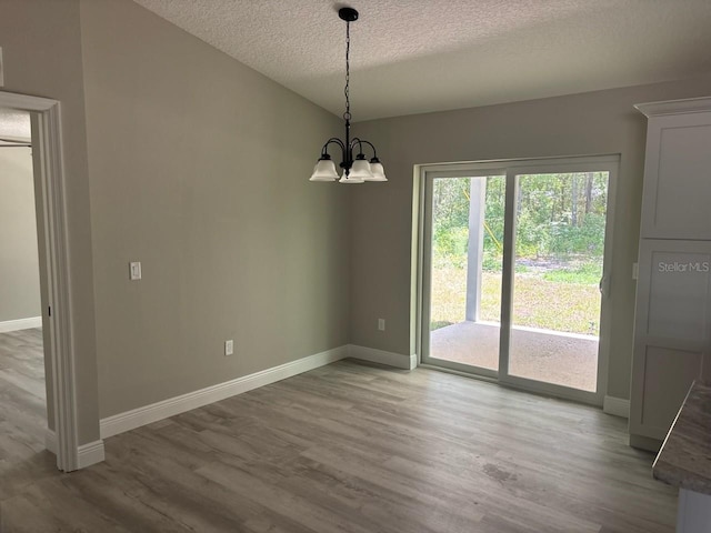 1176 W Bridge Dr, Citrus Springs, FL 34434 - unfurnished dining area with wood finished floors, a textured ceiling, and a chandelier
