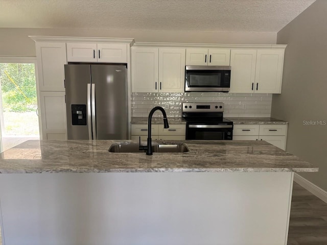 1176 W Bridge Dr, Citrus Springs, FL 34434 - kitchen with stainless steel appliances, backsplash, white cabinets, light stone countertops, and a textured ceiling