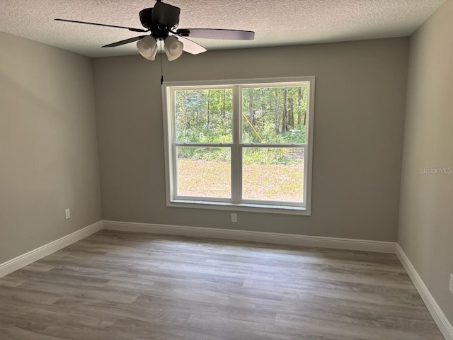 1176 W Bridge Dr, Citrus Springs, FL 34434 - spare room with a textured ceiling, wood finished floors, and a ceiling fan