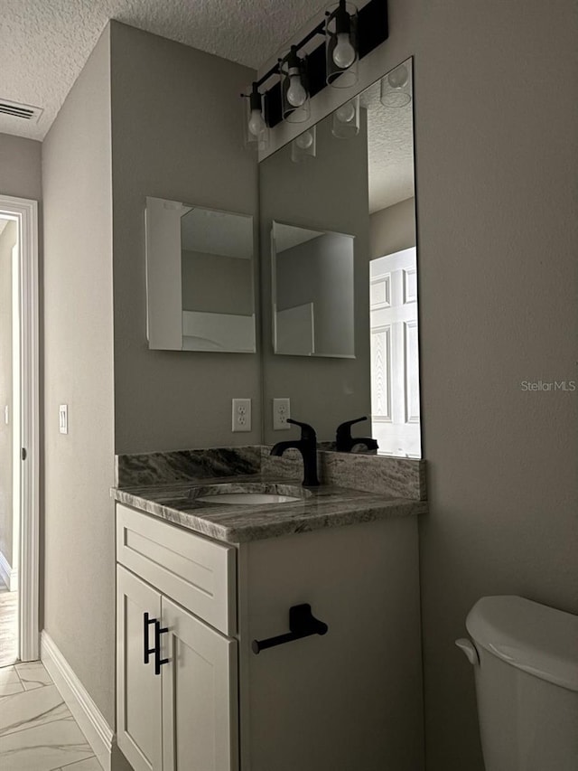 1176 W Bridge Dr, Citrus Springs, FL 34434 - bathroom featuring a textured ceiling, marble look tiles, and vanity