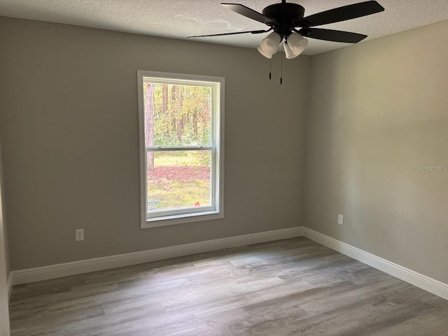 1176 W Bridge Dr, Citrus Springs, FL 34434 - empty room with a textured ceiling, wood finished floors, and ceiling fan
