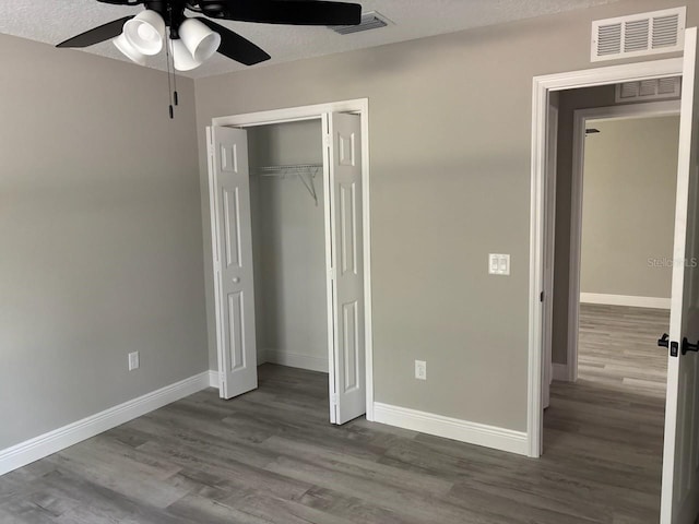 1176 W Bridge Dr, Citrus Springs, FL 34434 - unfurnished bedroom with dark wood-style flooring, a closet, and a ceiling fan