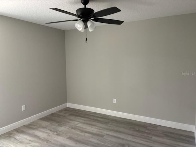 1176 W Bridge Dr, Citrus Springs, FL 34434 - empty room with wood finished floors, ceiling fan, and a textured ceiling