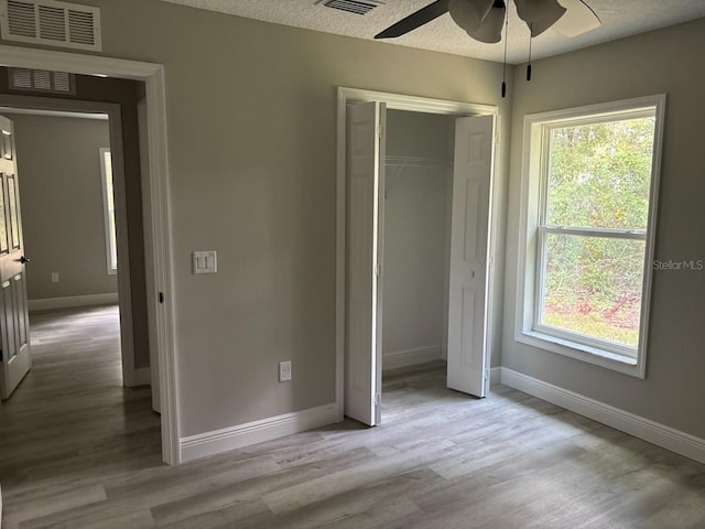1176 W Bridge Dr, Citrus Springs, FL 34434 - unfurnished bedroom featuring wood finished floors, a closet, and a ceiling fan