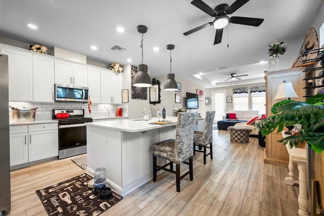 1055 Rustic Mill Dr, Saint Augustine, FL 32092 - kitchen with appliances with stainless steel finishes, ceiling fan, light countertops, light wood-style flooring, and backsplash