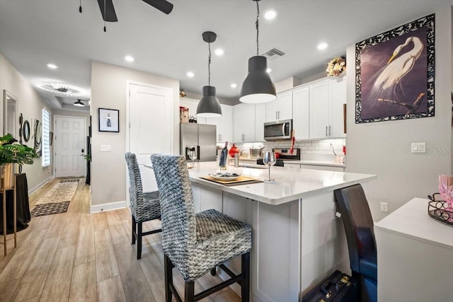 1055 Rustic Mill Dr, Saint Augustine, FL 32092 - kitchen with appliances with stainless steel finishes, light countertops, a breakfast bar, tasteful backsplash, and a ceiling fan