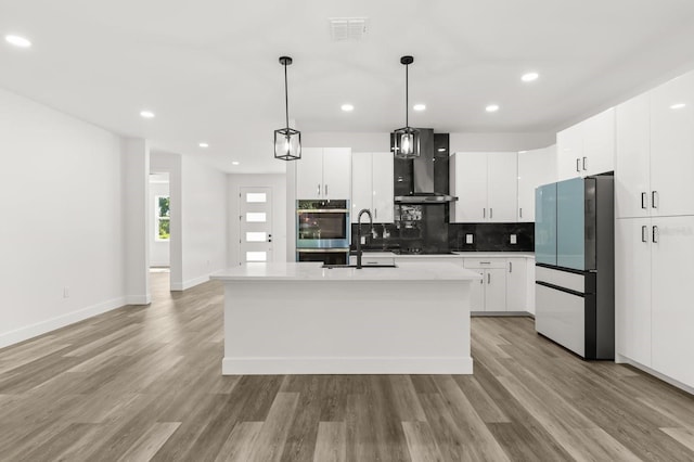 321 Watershore Dr, Leesburg, FL 34748 - kitchen featuring freestanding refrigerator, wall chimney range hood, stainless steel double oven, black cooktop, and decorative backsplash