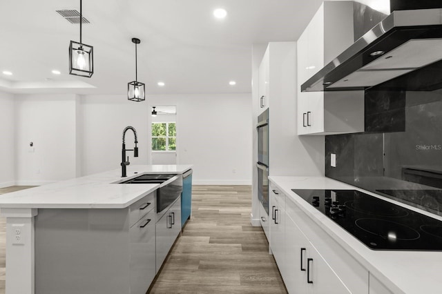 321 Watershore Dr, Leesburg, FL 34748 - kitchen with wall chimney range hood, appliances with stainless steel finishes, light wood-type flooring, white cabinets, and modern cabinets