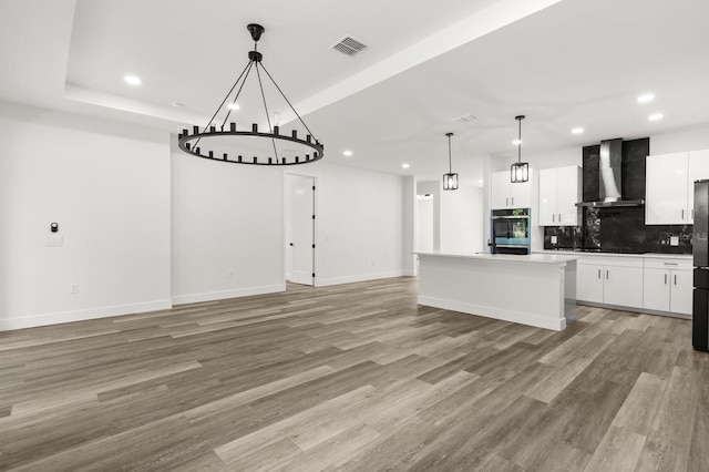 321 Watershore Dr, Leesburg, FL 34748 - kitchen with wall chimney exhaust hood, recessed lighting, refrigerator, backsplash, and white cabinetry