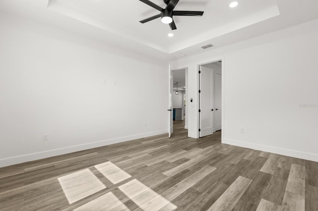 321 Watershore Dr, Leesburg, FL 34748 - empty room featuring a tray ceiling, ceiling fan, recessed lighting, and wood finished floors