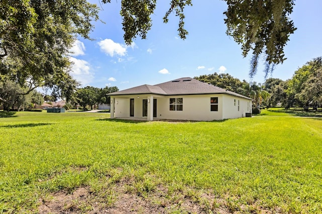 321 Watershore Dr, Leesburg, FL 34748 - back of house featuring stucco siding and a lawn