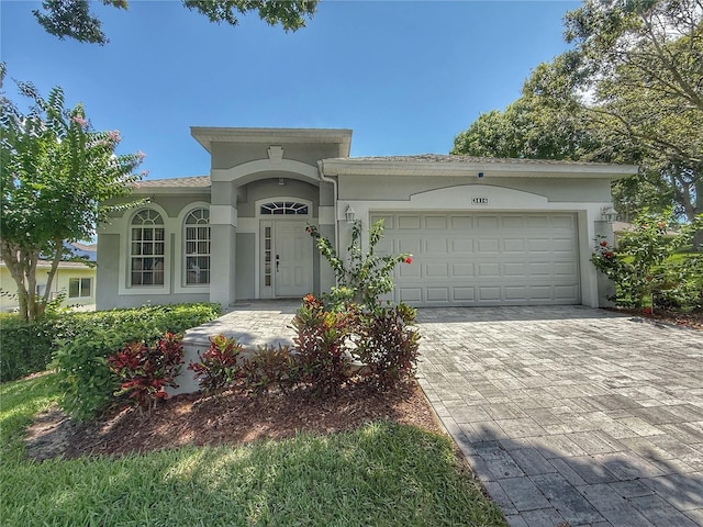 3416 Capland Ave, Clermont, FL 34711 - view of front of property with decorative driveway, an attached garage, and stucco siding