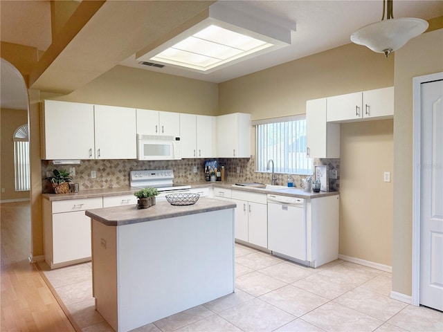 3416 Capland Ave, Clermont, FL 34711 - kitchen with white appliances, decorative backsplash, white cabinetry, and a center island