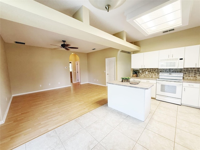 3416 Capland Ave, Clermont, FL 34711 - kitchen featuring white appliances, a center island, tasteful backsplash, and light countertops