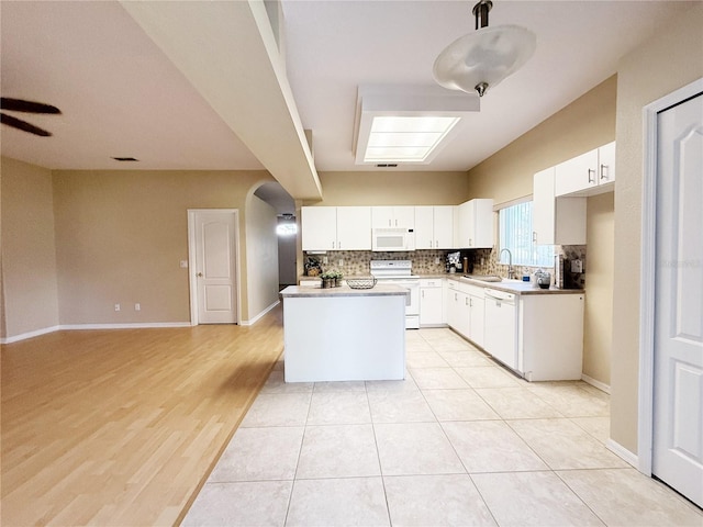 3416 Capland Ave, Clermont, FL 34711 - kitchen with white appliances, decorative backsplash, a kitchen island, white cabinetry, and light countertops