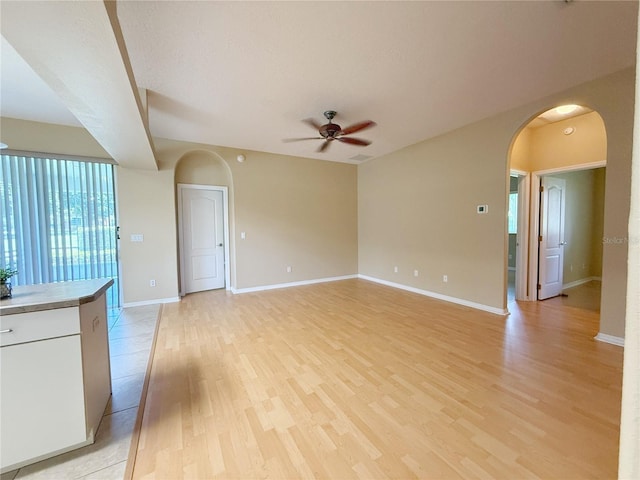 3416 Capland Ave, Clermont, FL 34711 - unfurnished living room with arched walkways, ceiling fan, and light wood finished floors