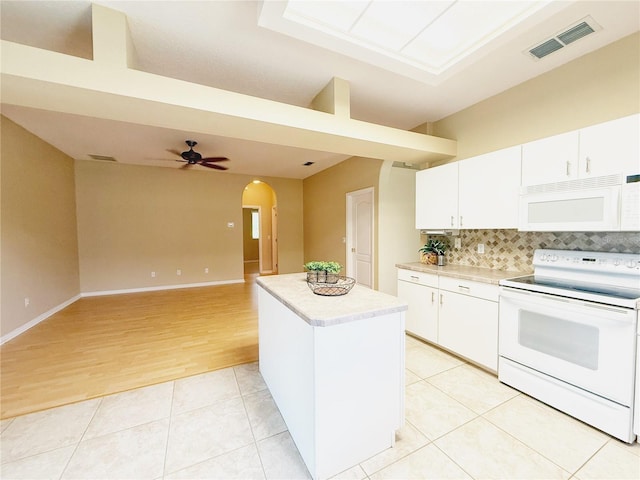 3416 Capland Ave, Clermont, FL 34711 - kitchen featuring white appliances, arched walkways, light countertops, a center island, and backsplash