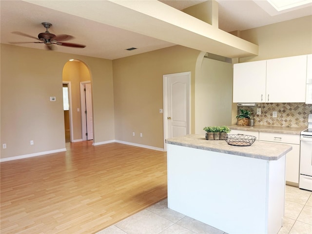 3416 Capland Ave, Clermont, FL 34711 - kitchen featuring arched walkways, white electric range, light countertops, ceiling fan, and decorative backsplash