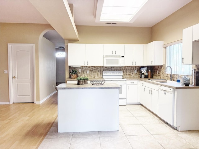 3416 Capland Ave, Clermont, FL 34711 - kitchen featuring white appliances, arched walkways, backsplash, and white cabinets