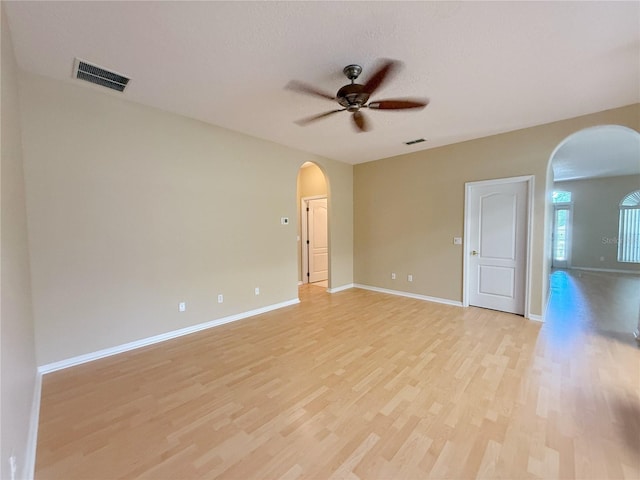 3416 Capland Ave, Clermont, FL 34711 - empty room with arched walkways, a ceiling fan, and light wood finished floors