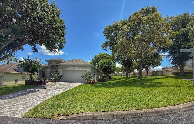 3416 Capland Ave, Clermont, FL 34711 - view of front of home with a front lawn, an attached garage, decorative driveway, and stucco siding