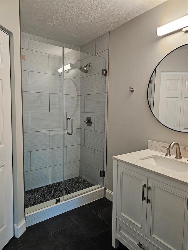 711 Sugar Bay Way Unit 115, Lake Mary, FL 32746 - full bath with a shower stall, a textured ceiling, vanity, and tile patterned flooring