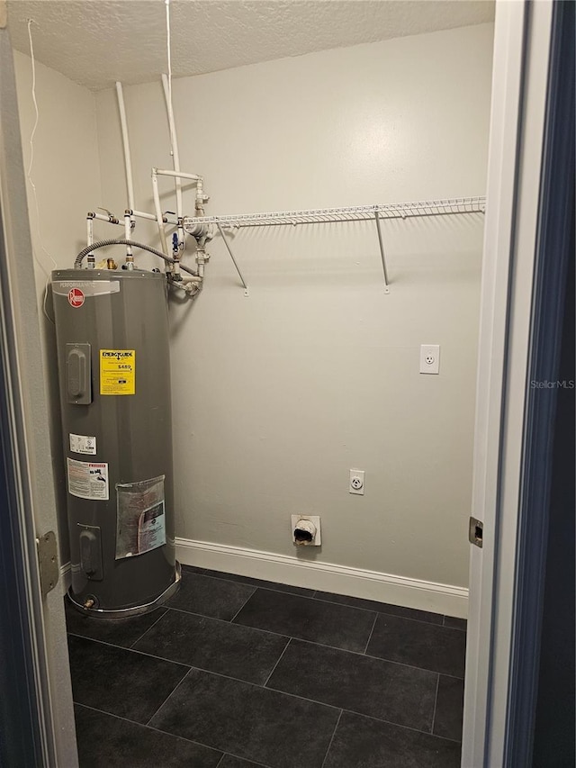 711 Sugar Bay Way Unit 115, Lake Mary, FL 32746 - laundry area with electric water heater, hookup for an electric dryer, dark tile patterned floors, and a textured ceiling