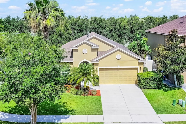 418 Rock Springs Cir, Groveland, FL 34736 - obstructed view of property featuring stucco siding, a garage, a front yard, and driveway