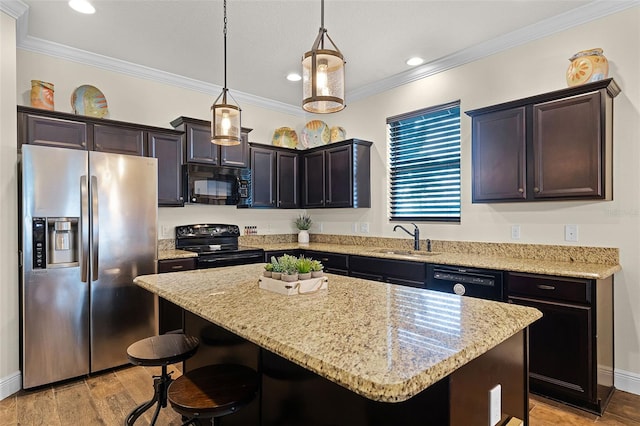 418 Rock Springs Cir, Groveland, FL 34736 - kitchen with black appliances, a center island, a breakfast bar area, light stone countertops, and hanging light fixtures