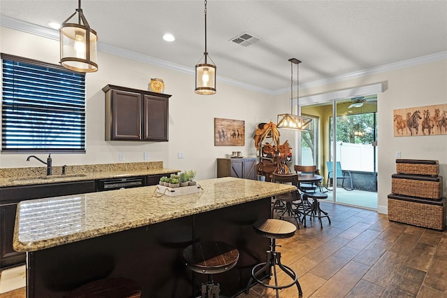 418 Rock Springs Cir, Groveland, FL 34736 - kitchen featuring dark wood-style floors, dark brown cabinets, ornamental molding, light stone counters, and a kitchen breakfast bar