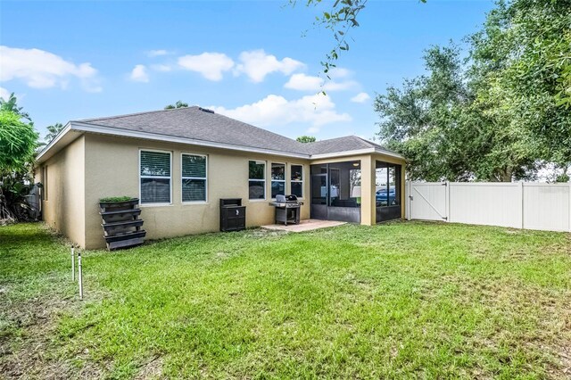 418 Rock Springs Cir, Groveland, FL 34736 - rear view of house featuring a sunroom, stucco siding, a fenced backyard, a gate, and roof with shingles