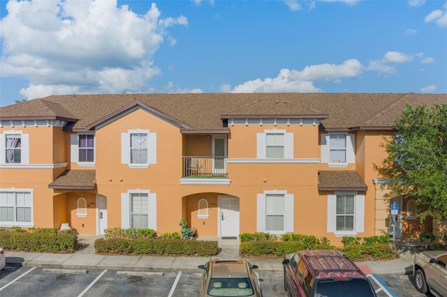 2717 Bushman Dr, Kissimmee, FL 34746 - view of property featuring stucco siding, uncovered parking, and roof with shingles
