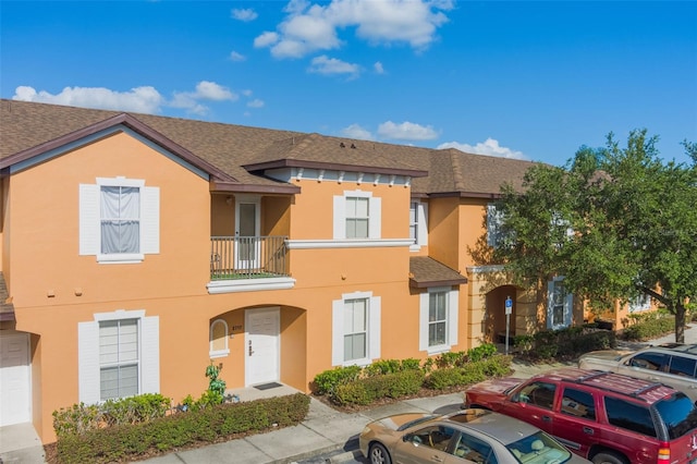 2717 Bushman Dr, Kissimmee, FL 34746 - townhome / multi-family property with stucco siding, a shingled roof, and a balcony