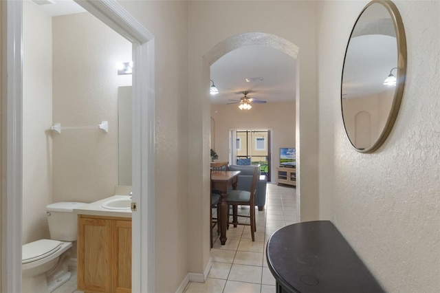 2717 Bushman Dr, Kissimmee, FL 34746 - corridor featuring light tile patterned floors, arched walkways, and a textured wall