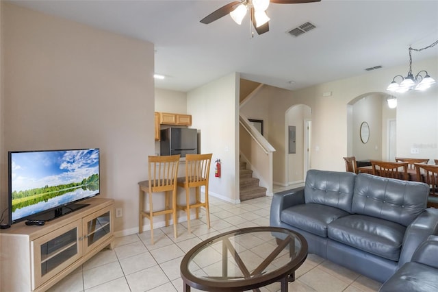 2717 Bushman Dr, Kissimmee, FL 34746 - living area featuring arched walkways, ceiling fan, stairs, light tile patterned flooring, and electric panel
