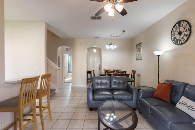 2717 Bushman Dr, Kissimmee, FL 34746 - living room featuring arched walkways, a ceiling fan, light tile patterned floors, and stairway