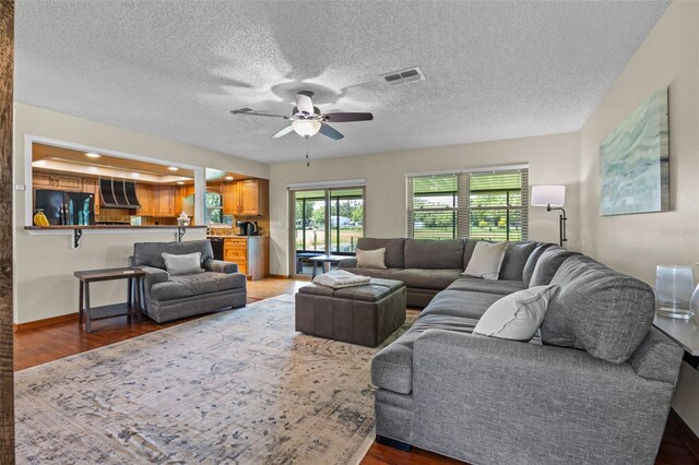 14325 Manchester Ave, Groveland, FL 34736 - living area featuring ceiling fan, wood finished floors, and a textured ceiling