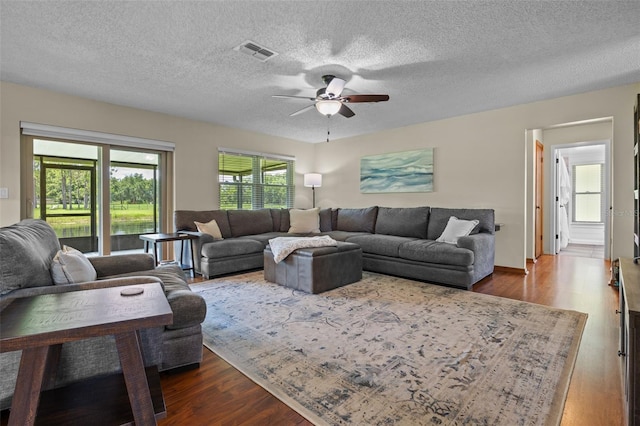14325 Manchester Ave, Groveland, FL 34736 - living area with dark wood-style flooring, a ceiling fan, and a textured ceiling