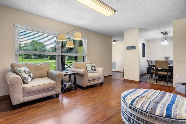 14325 Manchester Ave, Groveland, FL 34736 - living room with a textured ceiling, wood finished floors, and a chandelier