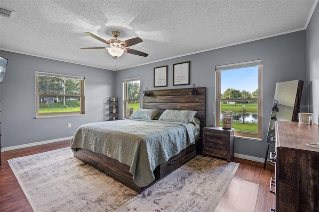 14325 Manchester Ave, Groveland, FL 34736 - bedroom featuring a textured ceiling, wood finished floors, crown molding, ceiling fan, and a water view
