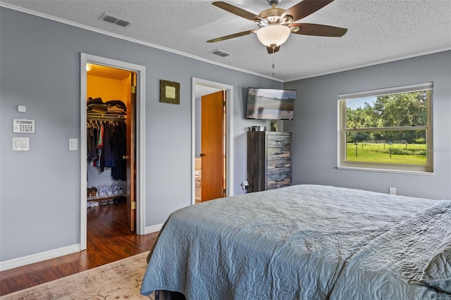 14325 Manchester Ave, Groveland, FL 34736 - bedroom with wood finished floors, a textured ceiling, a spacious closet, ornamental molding, and ceiling fan