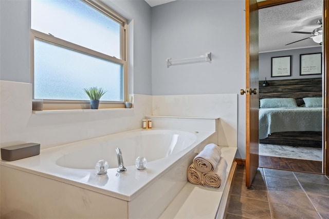 14325 Manchester Ave, Groveland, FL 34736 - full bath featuring healthy amount of natural light, ensuite bath, a bath, stone finish floors, and a textured ceiling