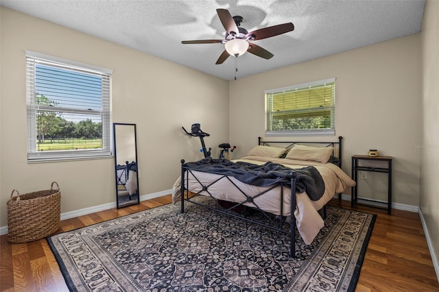 14325 Manchester Ave, Groveland, FL 34736 - bedroom featuring multiple windows, wood finished floors, a textured ceiling, and a ceiling fan