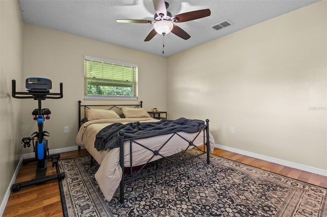 14325 Manchester Ave, Groveland, FL 34736 - bedroom featuring wood finished floors, ceiling fan, and a textured ceiling