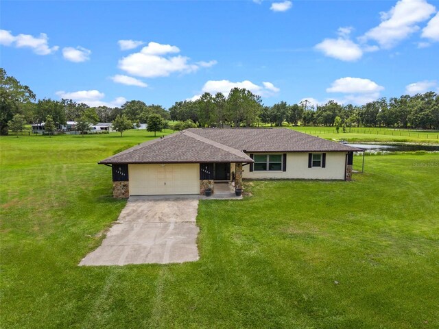 14325 Manchester Ave, Groveland, FL 34736 - single story home featuring a front lawn, a garage, concrete driveway, and view of wooded area
