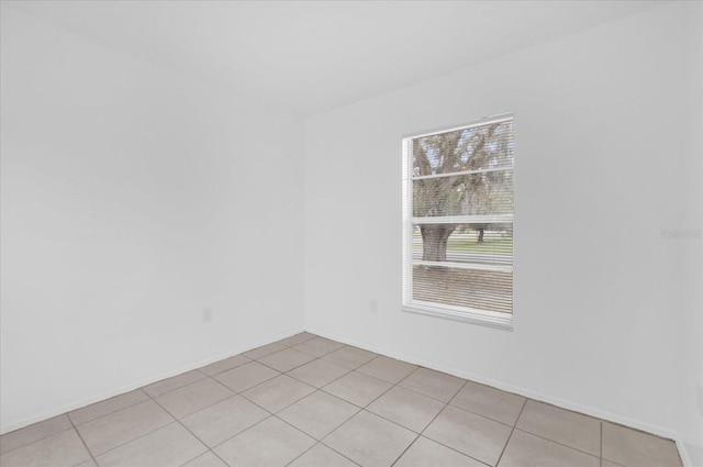 302 W Rose Ln, Lady Lake, FL 32159 - spare room with light tile patterned flooring and baseboards