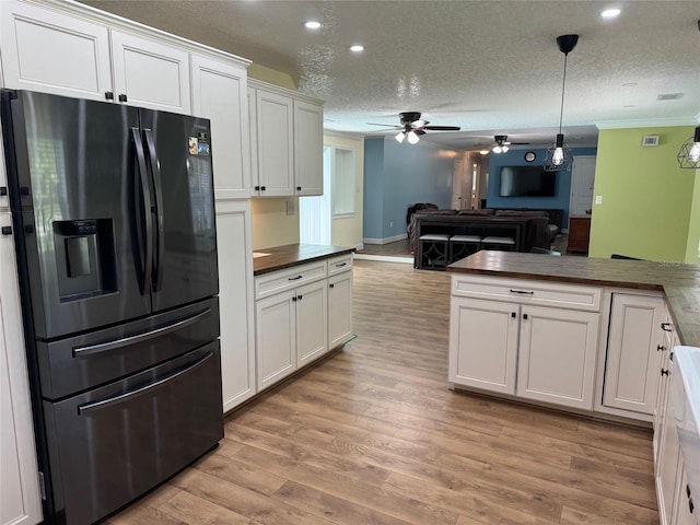 219 Magnolia Cir, Eustis, FL 32726 - kitchen featuring fridge with ice dispenser, a ceiling fan, crown molding, light wood-style floors, and white cabinets